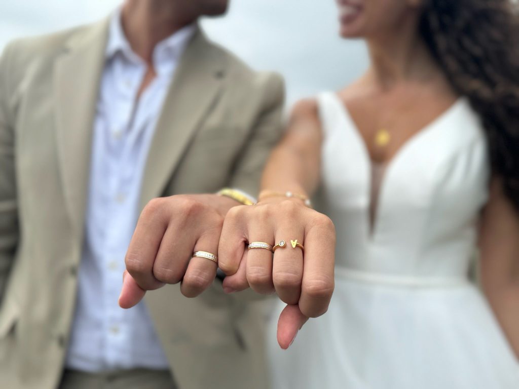 novios dados de la mano mostrando sus alianzas